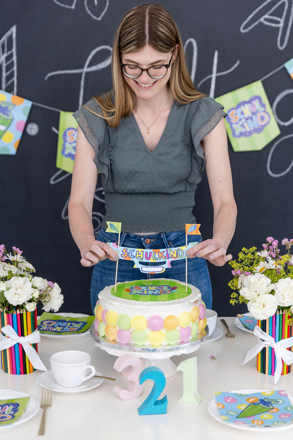 Farbenfrohe Tischdekoration mit Kuchen und Tortenbanner für die Einschulgungsfeier.