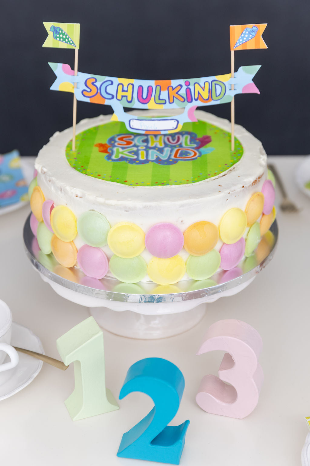 Buntes Tortenbanner zur Einschulung als festliche Dekoration auf einer Torte.