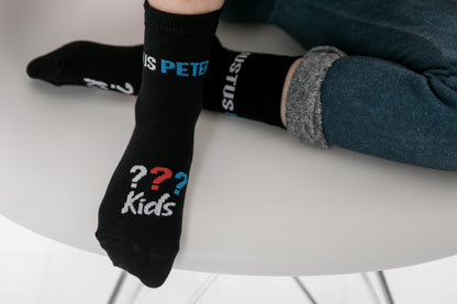 Ein Kind trägt die schwarzen die Drei ??? Kids Socken.